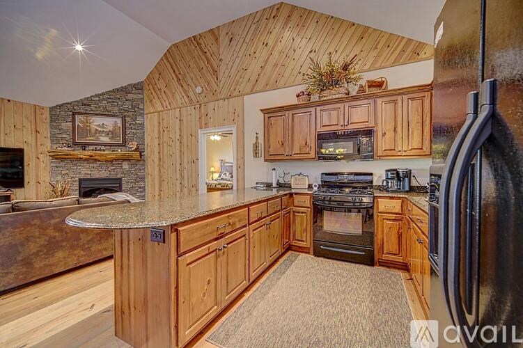 A kitchen with wooden cabinets and a stone fireplace.