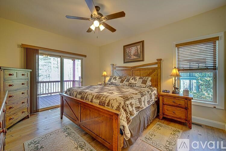A bedroom with a large bed, a dresser, and a ceiling fan.