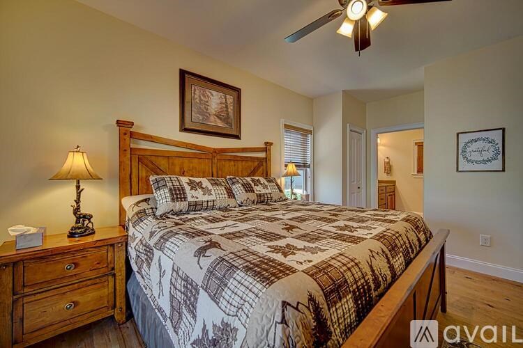 A bedroom with a bed, dresser, and a ceiling fan.