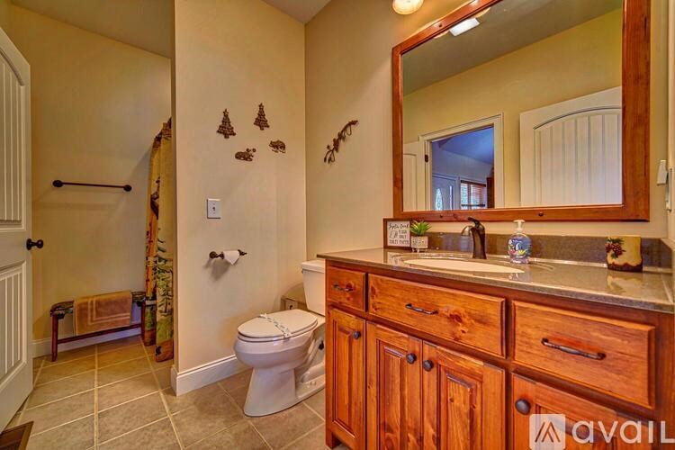 A bathroom with a toilet, sink, and mirror.