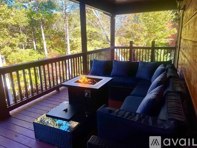 A balcony with a black couch and a table with a book on it.