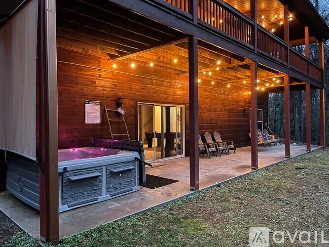A wooden building with a hot tub and string lights.
