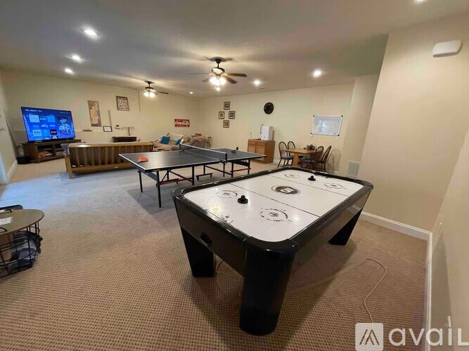 A room with a pool table and a television.