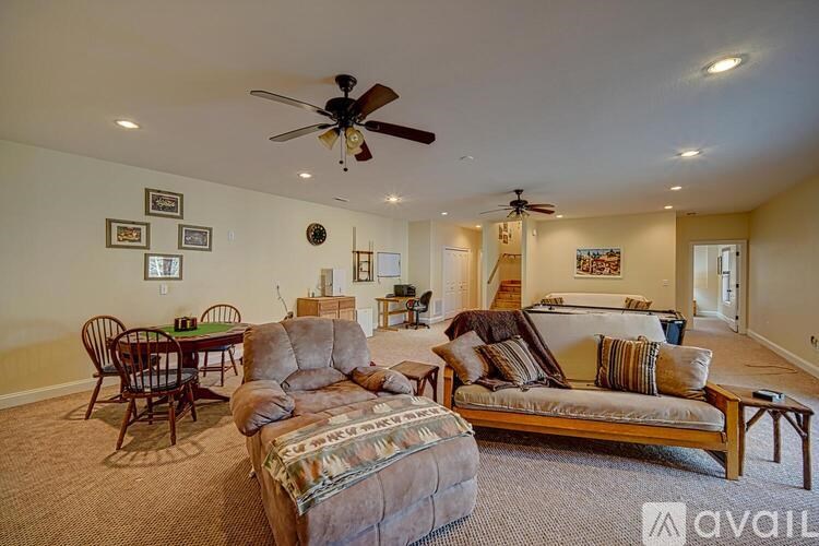 A living room with a couch, chairs, and a dining table.