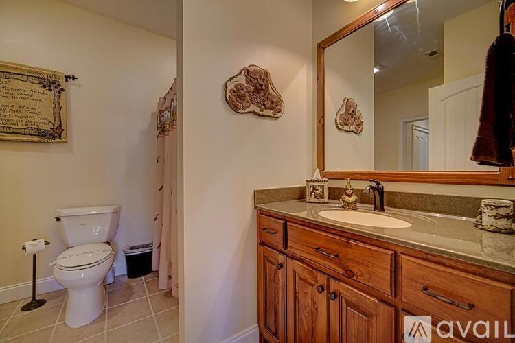 A bathroom with a toilet, sink, and mirror.
