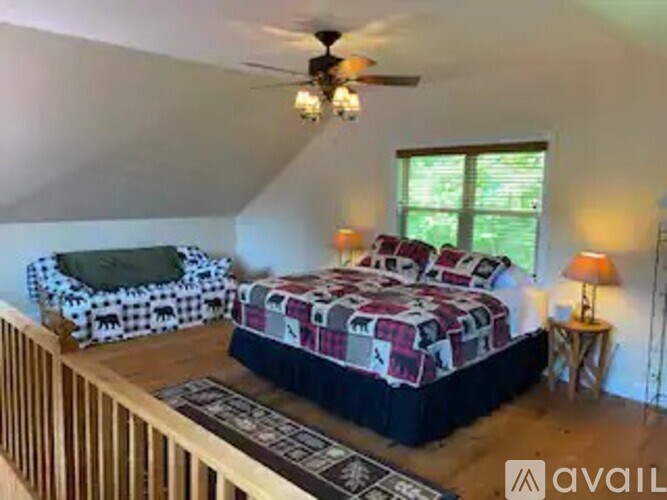 A bedroom with a bed, a chair, and a ceiling fan.