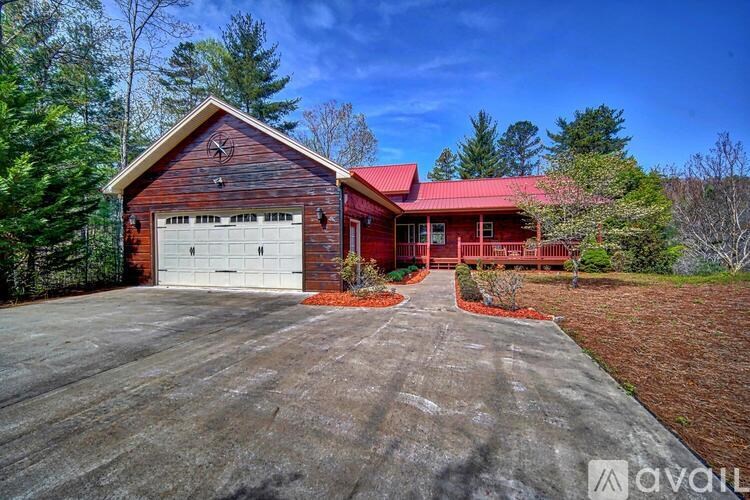 A house with a red roof and a garage door is for sale.