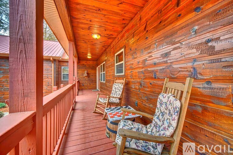 A wooden porch with two chairs and a table.