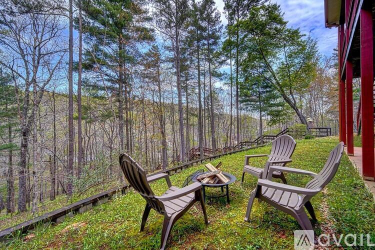 A patio with two chairs and a table overlooks a wooded area.