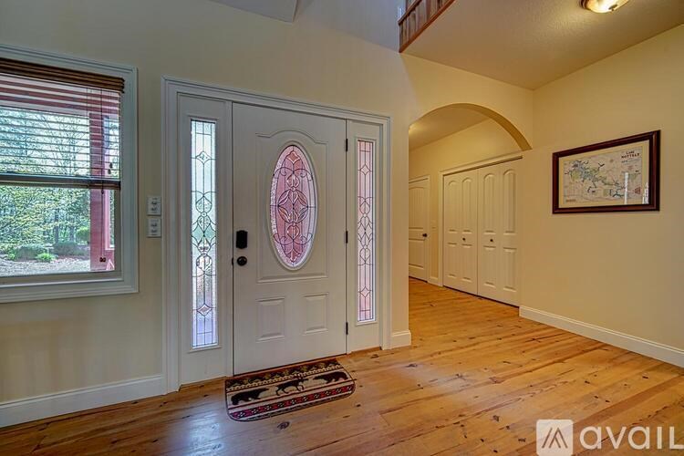 A room with a wooden floor and a white door with a glass window.