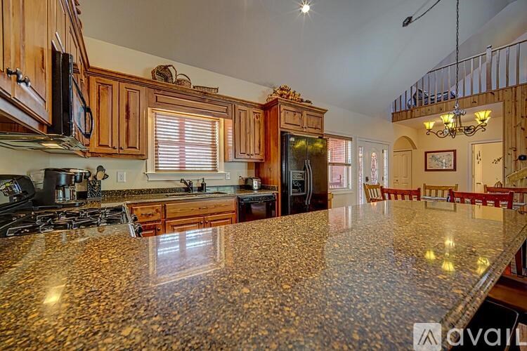 A kitchen with granite countertops and wooden cabinets.
