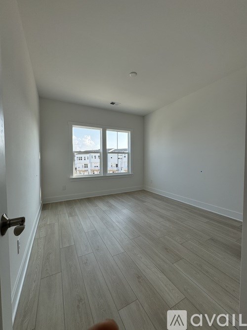A room with a door and a window overlooking a building.