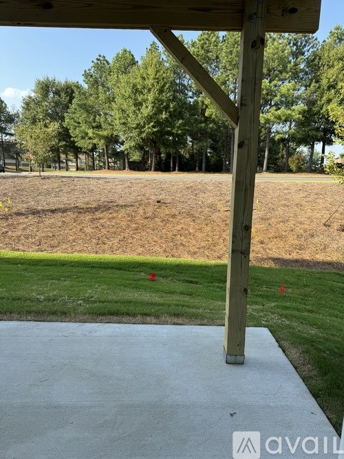 A wooden structure with a concrete slab in front of it.