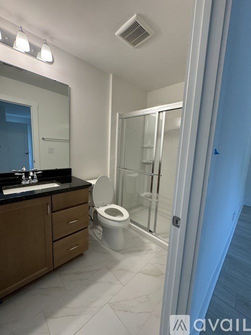 A bathroom with a toilet, sink, and mirror.