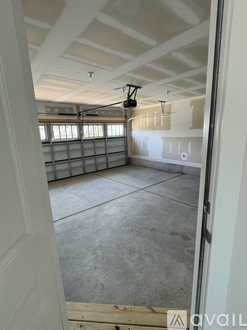 A room with a concrete floor and white walls is shown.