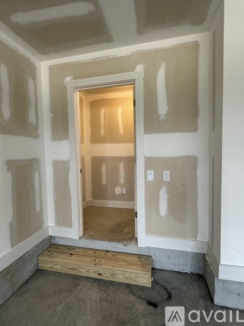 A room under construction with a doorway and a wooden step.