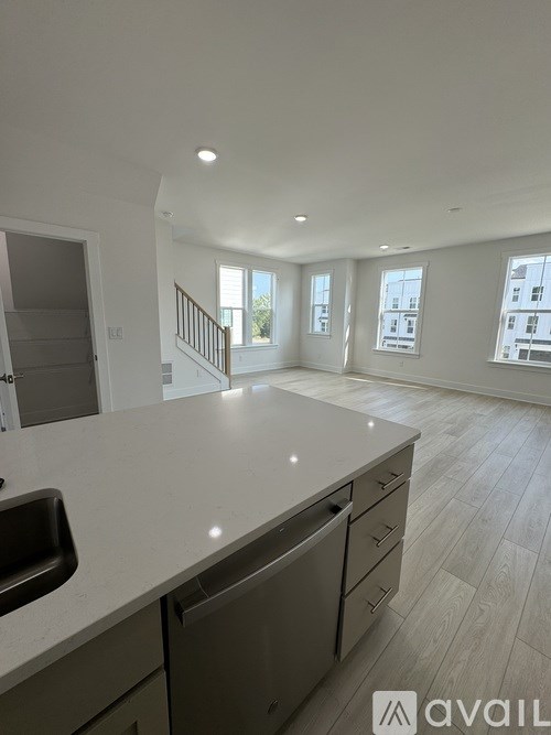 A kitchen with a sink, stove, and cabinets.