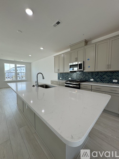 A kitchen with a white countertop and a sink.