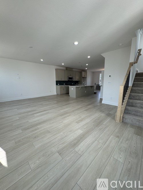 A spacious living room with a staircase on the right side.