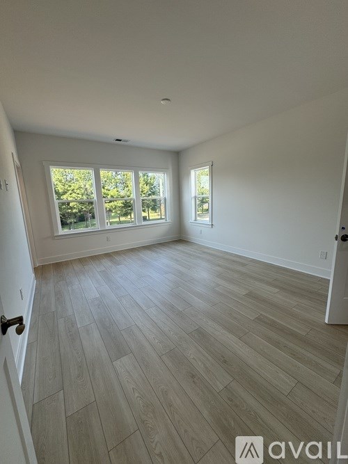 A room with light wood flooring and white walls.