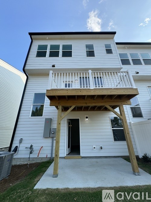 A two-story white house with a balcony and a deck.