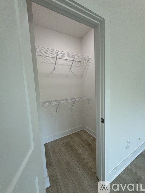 A white closet with a wire shelving unit and a white door.