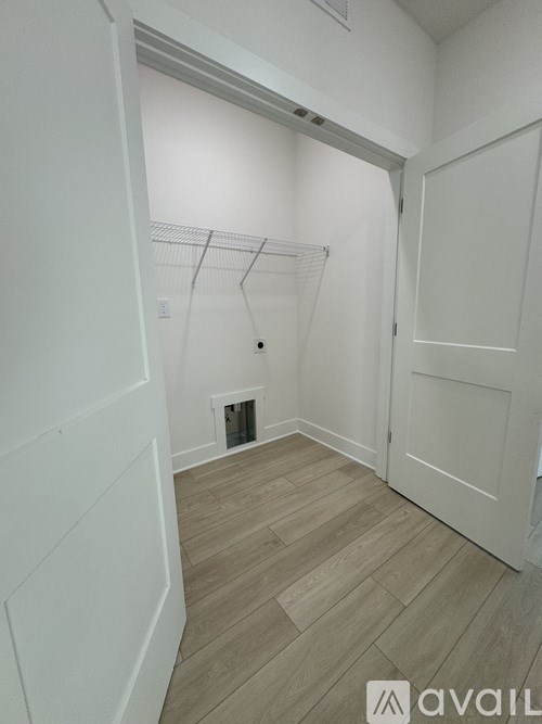 A hallway with a white door and a white wall.