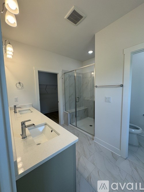 A bathroom with a sink, mirror, and shower.