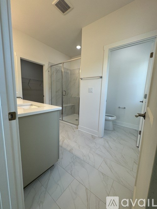 A bathroom with a walk-in shower and a toilet.