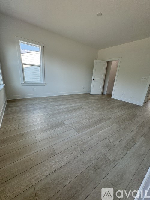 A room with wooden flooring and a window.