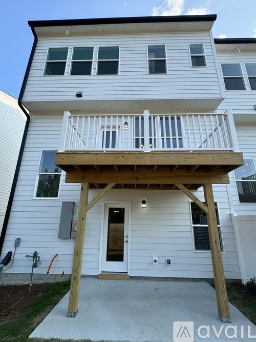 A two-story white house with a balcony and a door.