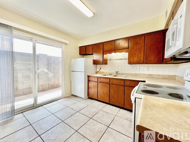 A kitchen with white appliances and wooden cabinets.