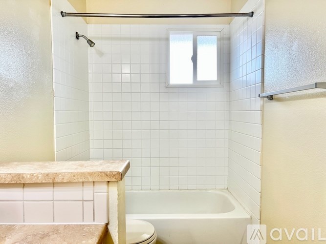 A bathroom with a tub, toilet, and sink.