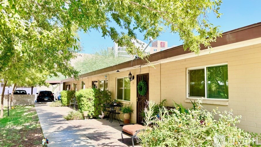 A sunny day at a residential area with a house and a parked car.