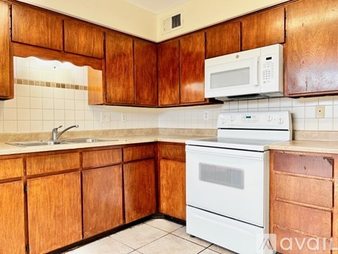 A kitchen with wooden cabinets and white appliances.