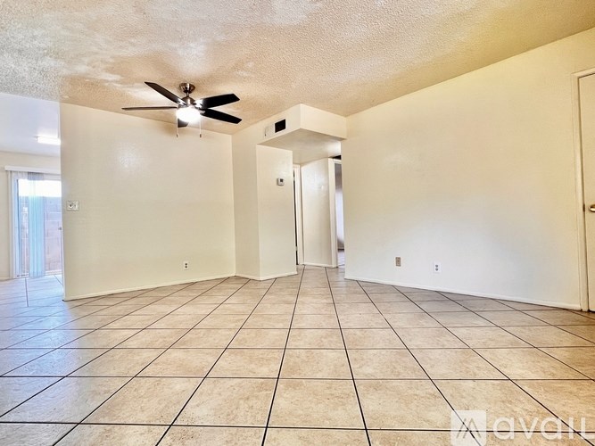 A spacious room with a ceiling fan and tile flooring.