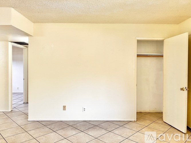 A room with a white wall and a tile floor.