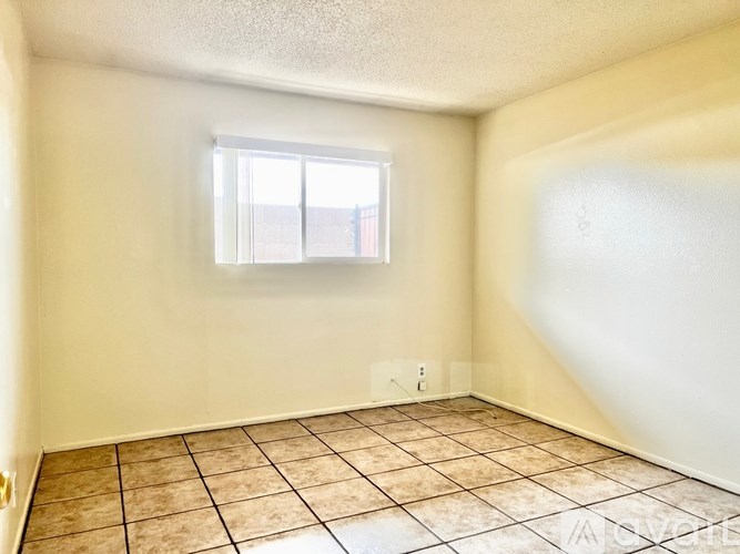 A room with a window and tiled floor.