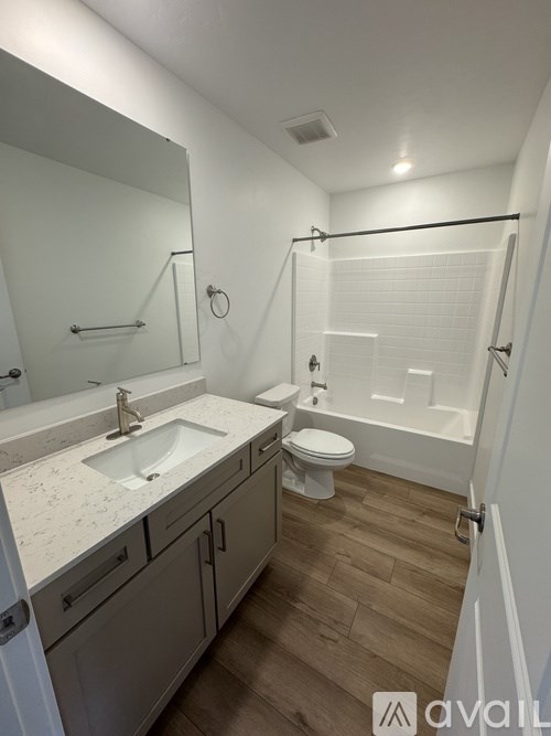 A bathroom with a sink, toilet, and bathtub.