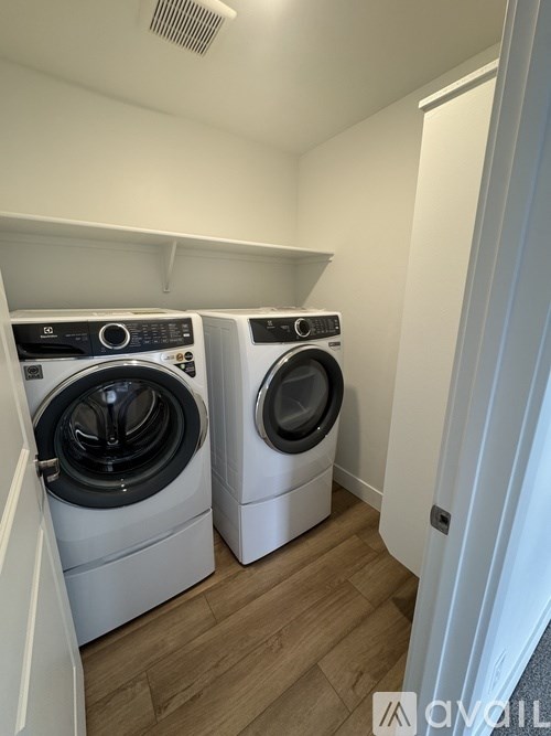 Two front load washing machines in a small laundry room.