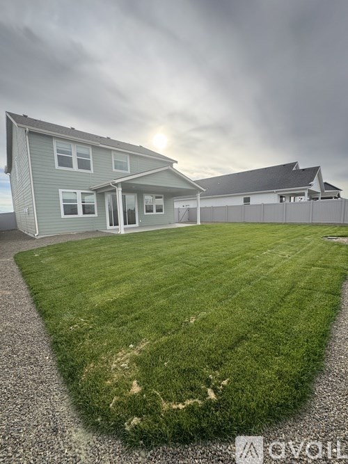 A house with a grey roof and a green lawn in front.