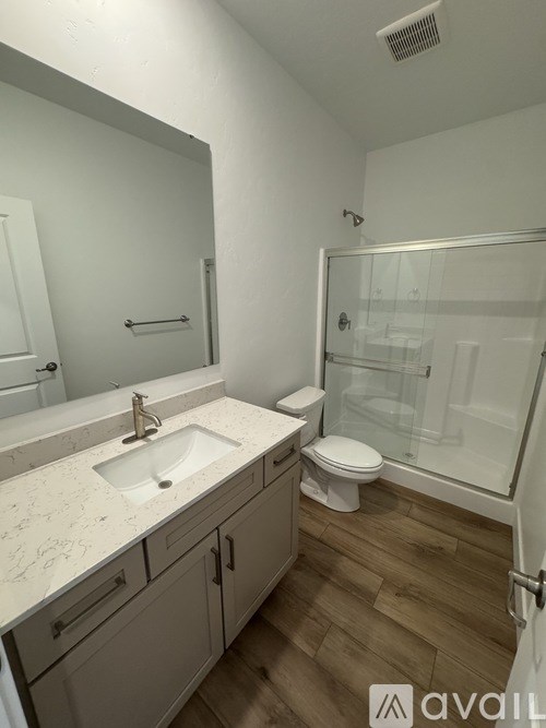 A bathroom with a sink, toilet, and shower.