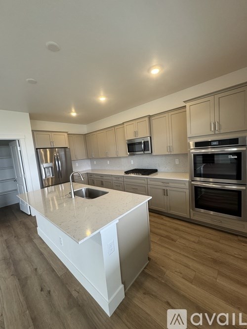 A kitchen with a white island and wooden cabinets.