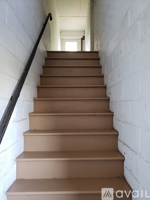 A staircase with a black railing and white walls.