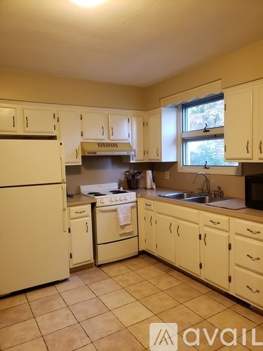 A kitchen with white appliances and cabinets.