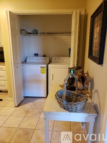A kitchen with a white fridge and a basket on a table.