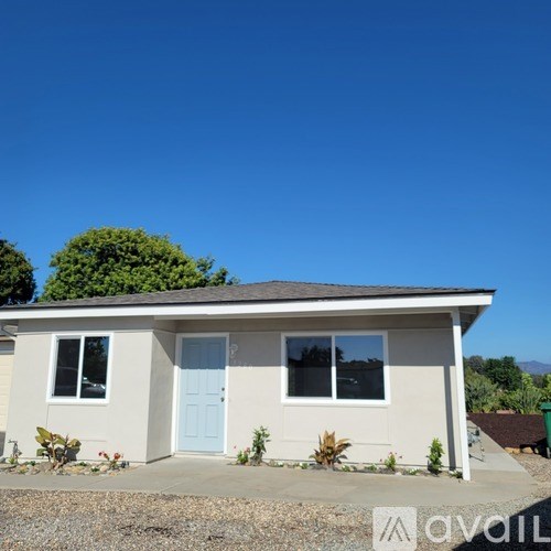 A house with a blue door and a white wall is for sale.