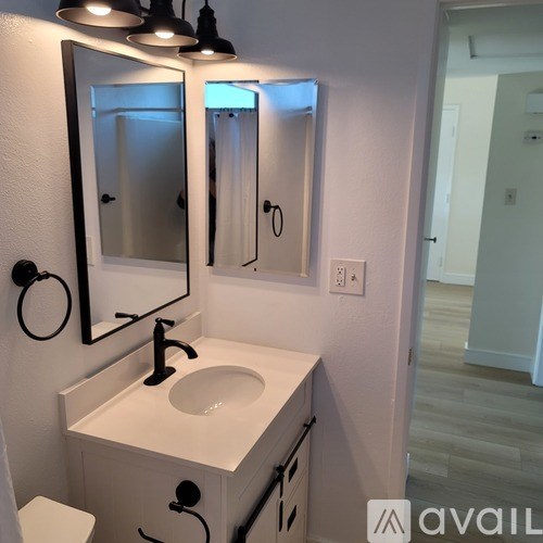 A bathroom with a sink, mirror, and toilet.