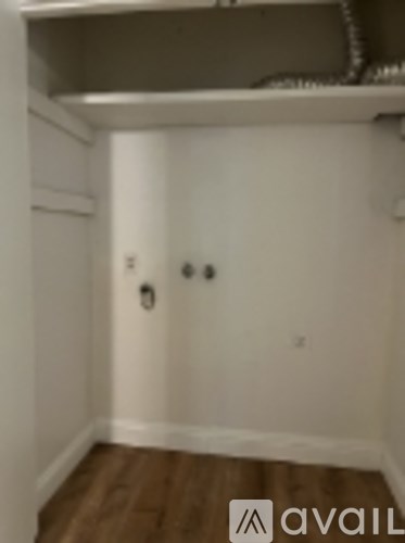 A small, empty room with a shelf and two doors.