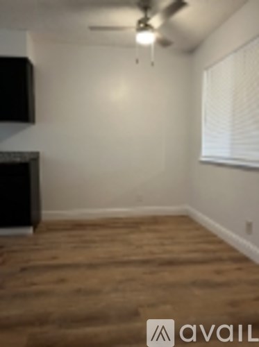 A room with a wooden floor and a ceiling fan.